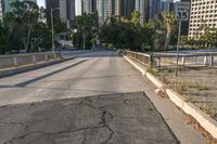 the road is wide and empty next to the city buildings on the other side of the street