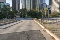 the road is wide and empty next to the city buildings on the other side of the street