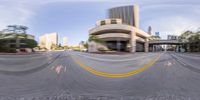 this is an image of a empty street in the city at daytime, with buildings and cars going up to their sides