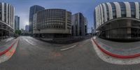 a street and some tall buildings with windows in them, seen through fisheyes