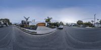 a city street and cars with buildings in the background as seen from a 360 - lens