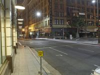 the intersection of a city street is lit by bright lights at night with no traffic and no cars