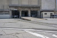 a red fire hydrant is located in an empty industrial area, with old buildings