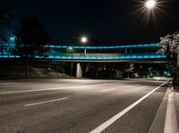 a couple of street lights that are on a bridge above an empty road and sidewalk