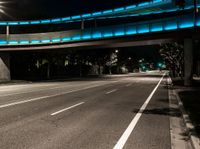 a couple of street lights that are on a bridge above an empty road and sidewalk