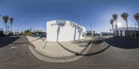 a 360 - view image shows an empty city street, with palm trees in the distance