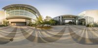 a 360 - camera shot of an entrance to a large building in the city at sunset