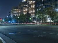 a night scene of the city lights on a street corner with an empty parking lot