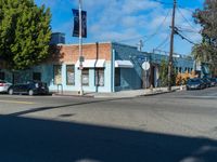 a small building on the street, where cars are parked and parked at the corner