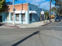 a small building on the street, where cars are parked and parked at the corner