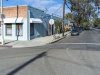 a small building on the street, where cars are parked and parked at the corner