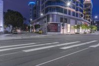 a cross walk with a building in the background on a cloudy day at night time