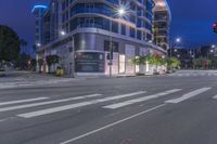 a cross walk with a building in the background on a cloudy day at night time