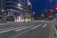 a cross walk with a building in the background on a cloudy day at night time