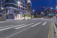 a cross walk with a building in the background on a cloudy day at night time