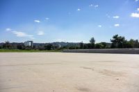 there is a skate board in the empty street area with a view of cityscape in the distance