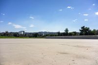 there is a skate board in the empty street area with a view of cityscape in the distance