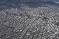 an aerial photograph of a city surrounded by mountains and hills with lots of snow on the ground