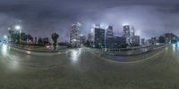 a street and street view with skyscrapers in the background at night time and bright light on buildings