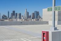 there is a fire box in the parking lot with city in the background, from which it would be a public space to park on top