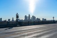 a view of a city with a bridge going over it and a man walking down the sidewalk