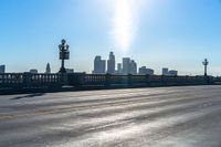 a view of a city with a bridge going over it and a man walking down the sidewalk