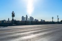 a view of a city with a bridge going over it and a man walking down the sidewalk