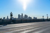 a view of a city with a bridge going over it and a man walking down the sidewalk