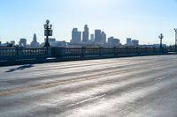 a view of a city with a bridge going over it and a man walking down the sidewalk