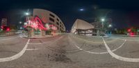 a photo of the intersection of two roads at night and lit up with neon graffiti