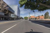 the city street has many cars driving on it as well as large buildings and buildings