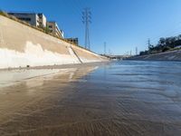 the brown water is flowing along the street as it flows down the shoreline near the city