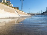 the brown water is flowing along the street as it flows down the shoreline near the city