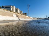 the brown water is flowing along the street as it flows down the shoreline near the city