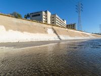 the brown water is flowing along the street as it flows down the shoreline near the city