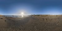 a fisheye lens panoramic image of the beach at sunset and the waves crashing on it