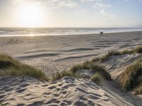 there is an image of a beach at sunset with a view of the ocean and sand dunes