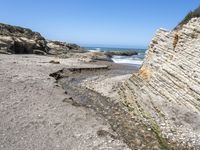 a beach has large rocks along with a very nice coastline area to the front and to the back