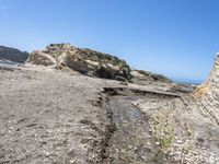 a beach has large rocks along with a very nice coastline area to the front and to the back