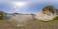 this is an 360 - view of the beach and water, from a fish eye lens