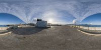 the view of some building and the ocean as seen through a fish eye lens in front of a fence