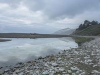 a view of the water from a shoreline in the fogy day at the edge