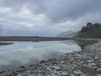 a view of the water from a shoreline in the fogy day at the edge