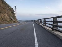 a paved road with a sea view on either side of it, and the ocean below