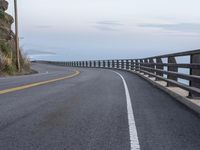 a paved road with a sea view on either side of it, and the ocean below