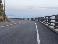 a paved road with a sea view on either side of it, and the ocean below