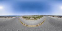 the view looking up at the empty road and ocean in the distance with no trees on either side