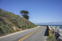 a paved road leading down to the beach and ocean on a clear day at the beach