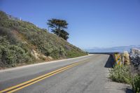 a paved road leading down to the beach and ocean on a clear day at the beach