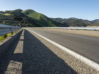 a motorcycle is parked on a highway with mountains in the background and mountains are visible